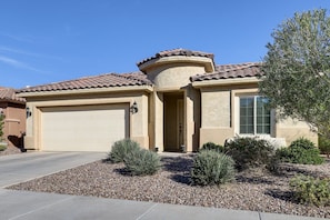 A residential building with a garage, a door, and a window with shutters. - Spend mornings exploring scenic desert trails, afternoons enjoying resort-style amenities, and evenings unwinding in comfort—With easy access to both Phoenix and Tucson, the location makes day trips simple (Florence)