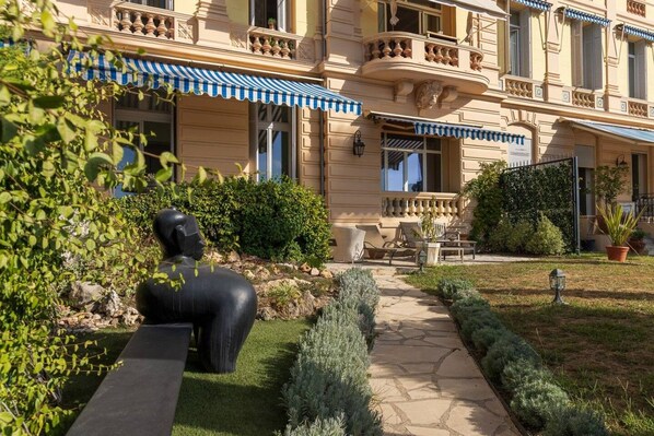 A hotel with a garden, outdoor seating, and a statue. - Belle Époque Flat with Garden & Sea View - Cannes (Cannes)