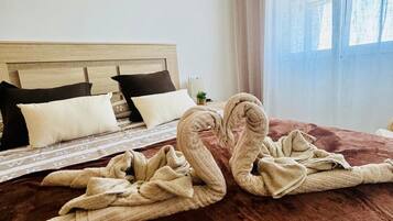Une chambre d’hôtel avec un lit, des oreillers, une table de chevet et une fenêtre avec des rideaux.