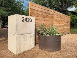 A concrete block with the number 2420, a wooden fence, and a potted plant. - PRD 2420 Rio Vista: Escape to the beautiful Guadalupe River (New Braunfels)