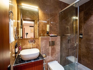 A modern bathroom with a marble sink, a glass shower enclosure, and a vanity with a mirror. - Deluxe Twin Room Hotel (Agra)