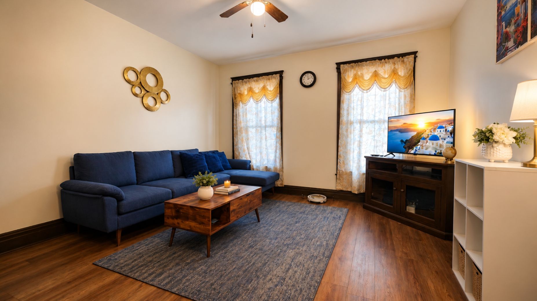 A living room with a blue sofa, a wooden coffee table, and a television on a stand.