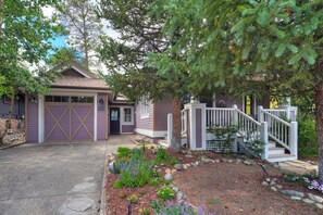 A residential property with a garage, a front porch, and a landscaped garden. - Fox Den on Historic French (Breckenridge)
