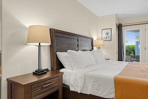 Bedroom with a wooden bed, bedside lamps, and an exterior door leading to a patio. - Modern Downtown HR Condo | Walk to Waterfront (Hood River)