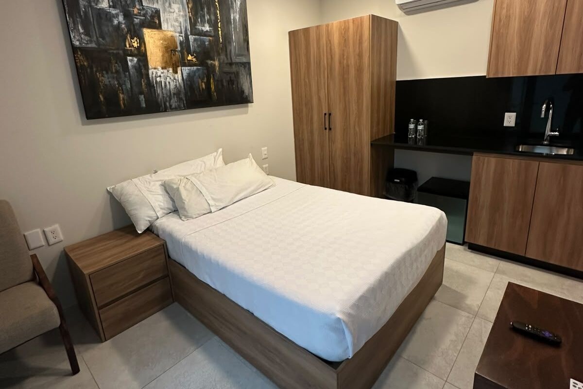 A modern bedroom with a bed, nightstand, and a small table.