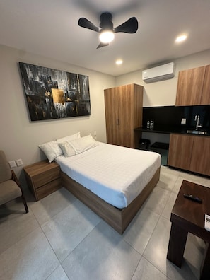 A modern bedroom with a bed, nightstand, and a small table. - Hotel Concordia (Guadalajara)