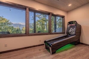 A room with a pool table, large windows, and a view of trees and mountains. - Mountain Views, Hot Tub & Game Room w/ Skee-Ball (Gatlinburg)