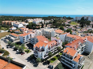A residential area with multi-story buildings, a parking lot, and a view of the sea. - Refúgio na Falésia | beach | golf | Alfamar and Falésia (Albufeira)