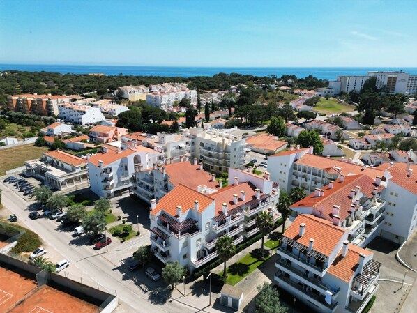 Ett bostadsområde med flerfamiljshus, en parkeringsplats och utsikt över havet.