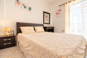 A bedroom with a bed, nightstands, a lamp, and wall art. - Andronikos TownHouse- Priv Balcony Stay in Preveza (Preveza)