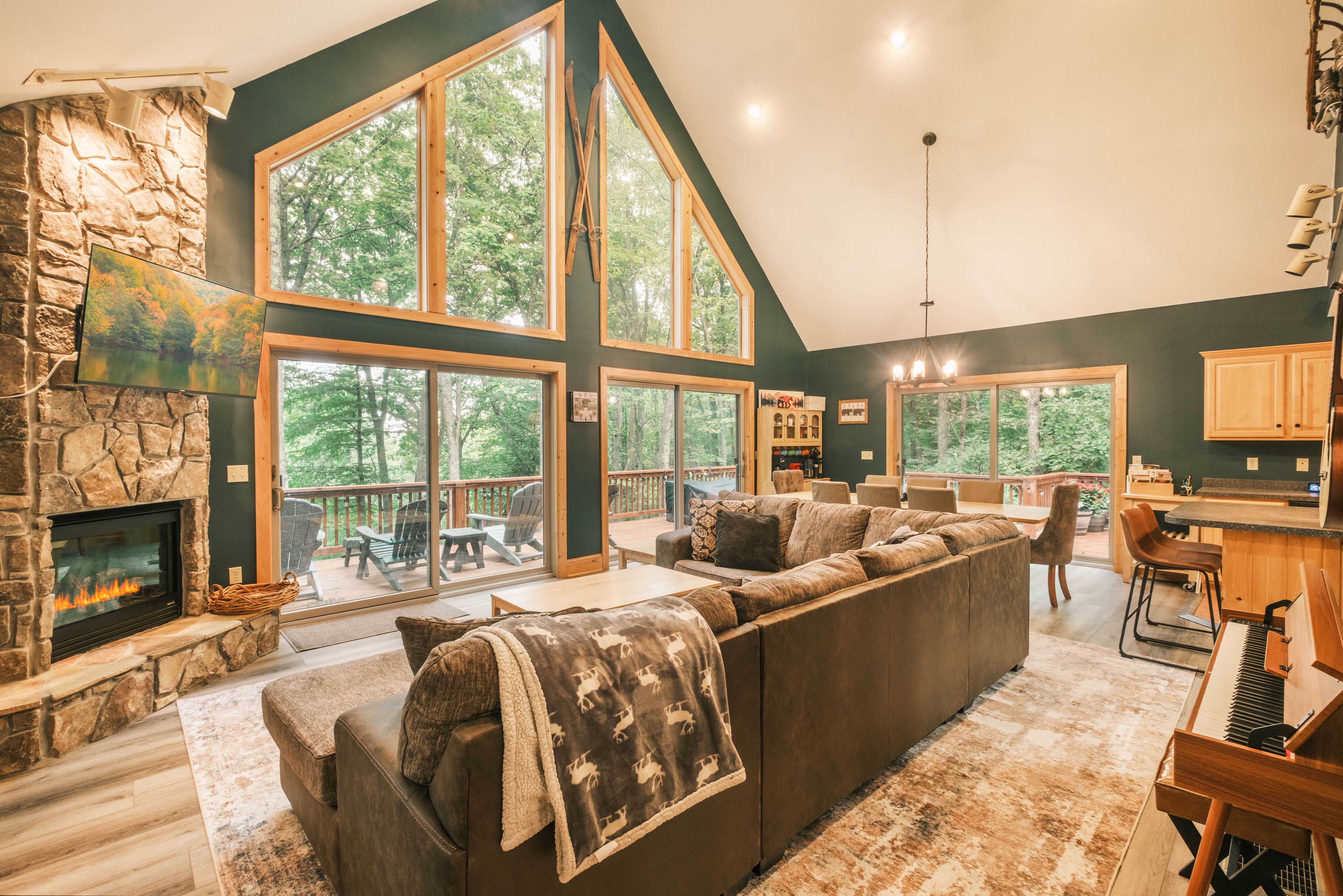 A spacious living room with a stone fireplace, large windows, and a cozy seating area.