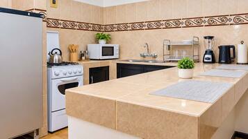Een moderne keuken met een centraal eiland, roestvrijstalen apparatuur en een decoratieve spatwand.