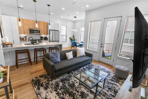 A modern apartment with a kitchen, dining area, and living room. - Peerless Place I 3BR Near NRG   Med Center (Houston)