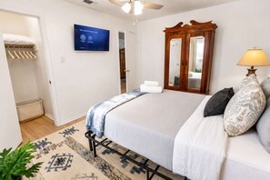 Ein Hotelzimmer mit einem Bett, einem Fernseher, einem Kleiderschrank und einem Spiegel.