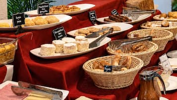 Una mesa de buffet con diversos alimentos y etiquetas en un comedor.