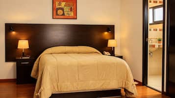 Habitación de hotel con una cama grande, dos lámparas de noche, un teléfono y un cuadro en la pared.