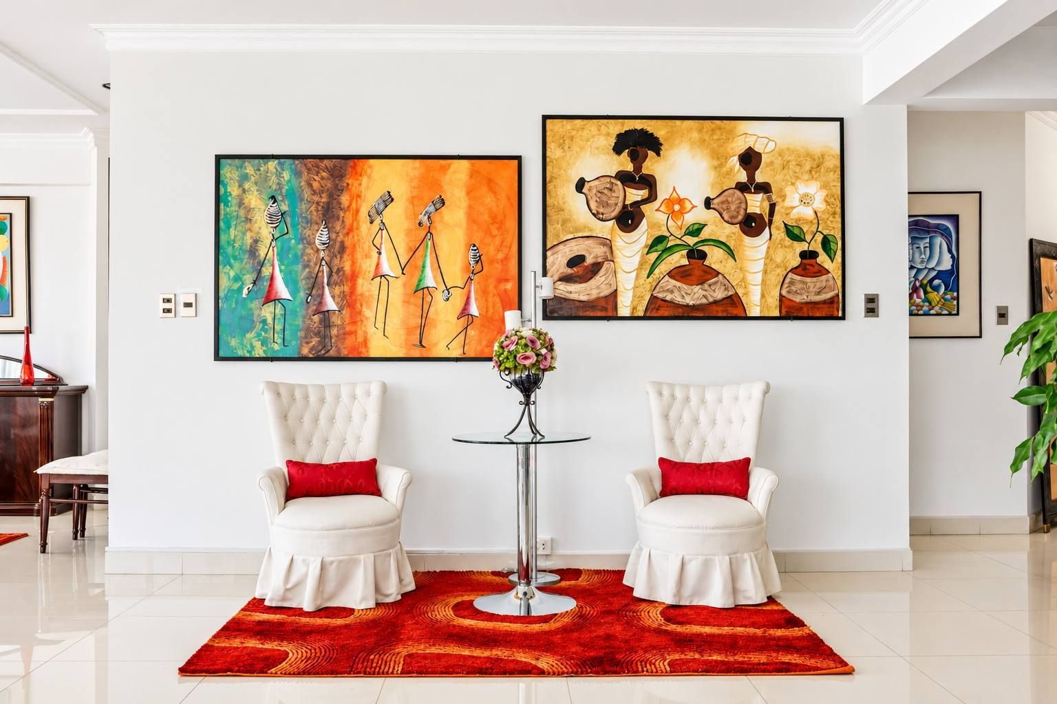 A modern living room with two white armchairs, a red rug, and two large paintings on the wall.