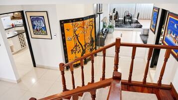 A staircase with wooden balusters leading to a living area with artwork on the walls.