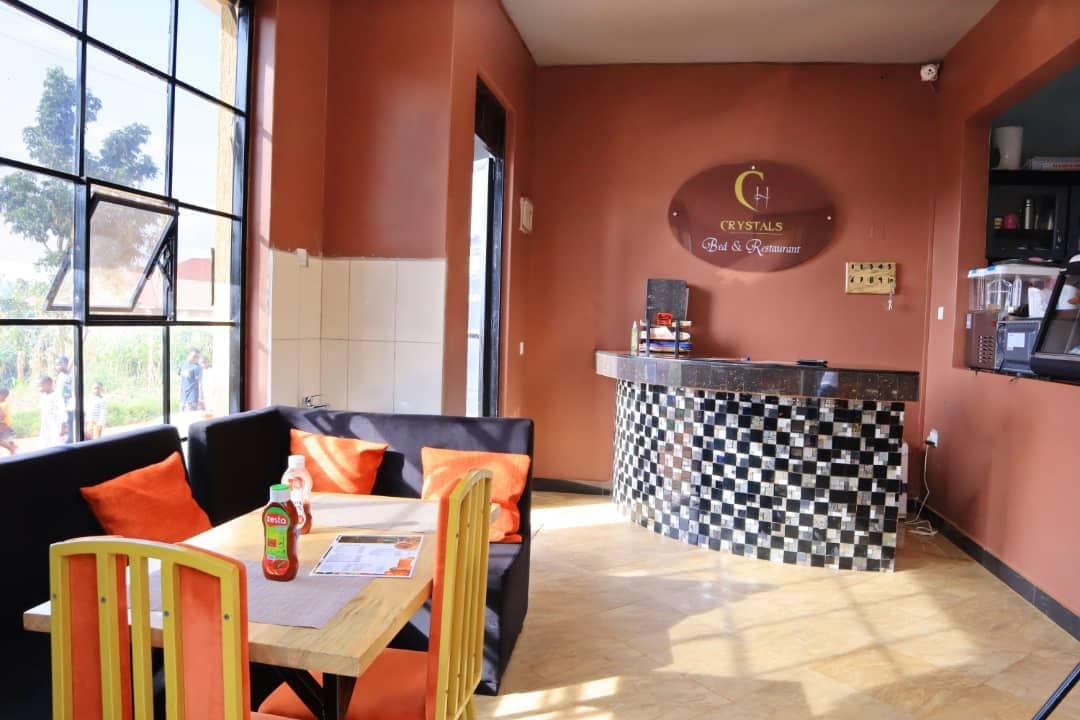 A restaurant interior with a checkered counter, seating area with orange cushions, and a visible menu.