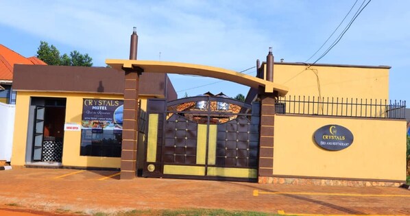 A gated entrance to a motel with a sign indicating it offers a bed and restaurant.