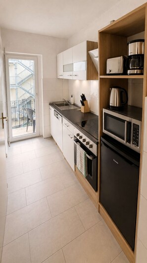 Een moderne keuken met een ingebouwde oven, magnetron en koffiezetapparaat.