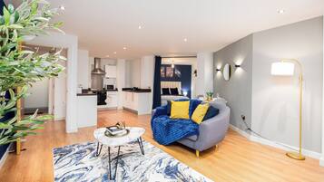 A modern living room with a sofa, a coffee table, and a blue and white patterned rug.