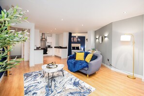 A modern living room with a sofa, a coffee table, and a blue and white patterned rug. - Spacious Riverside 2-Bed Apartment | Sleeps 5 | Contractor Stays (Leeds)