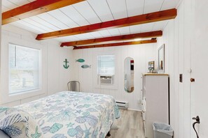 A bedroom with a bed, a dresser, a mirror, and a window. - Adorable Cottage With Patio & Walk to Sea St Beach (Dennis)