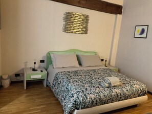 Une chambre à coucher avec un lit, des tables de chevet, une lampe et un élément de décoration murale.