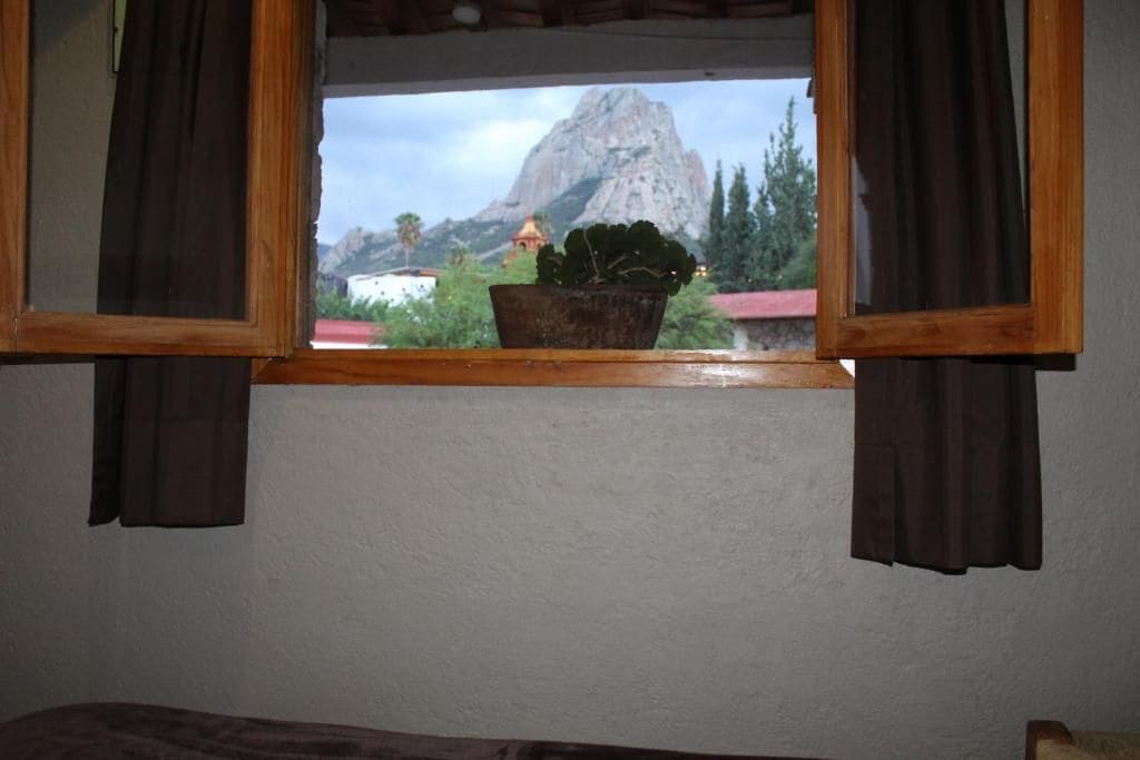 A window with a view of a mountain and a building.