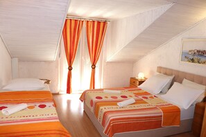 Ein Schlafzimmer mit zwei Betten, einem Nachttisch, einer Lampe und einem Bild an der Wand.