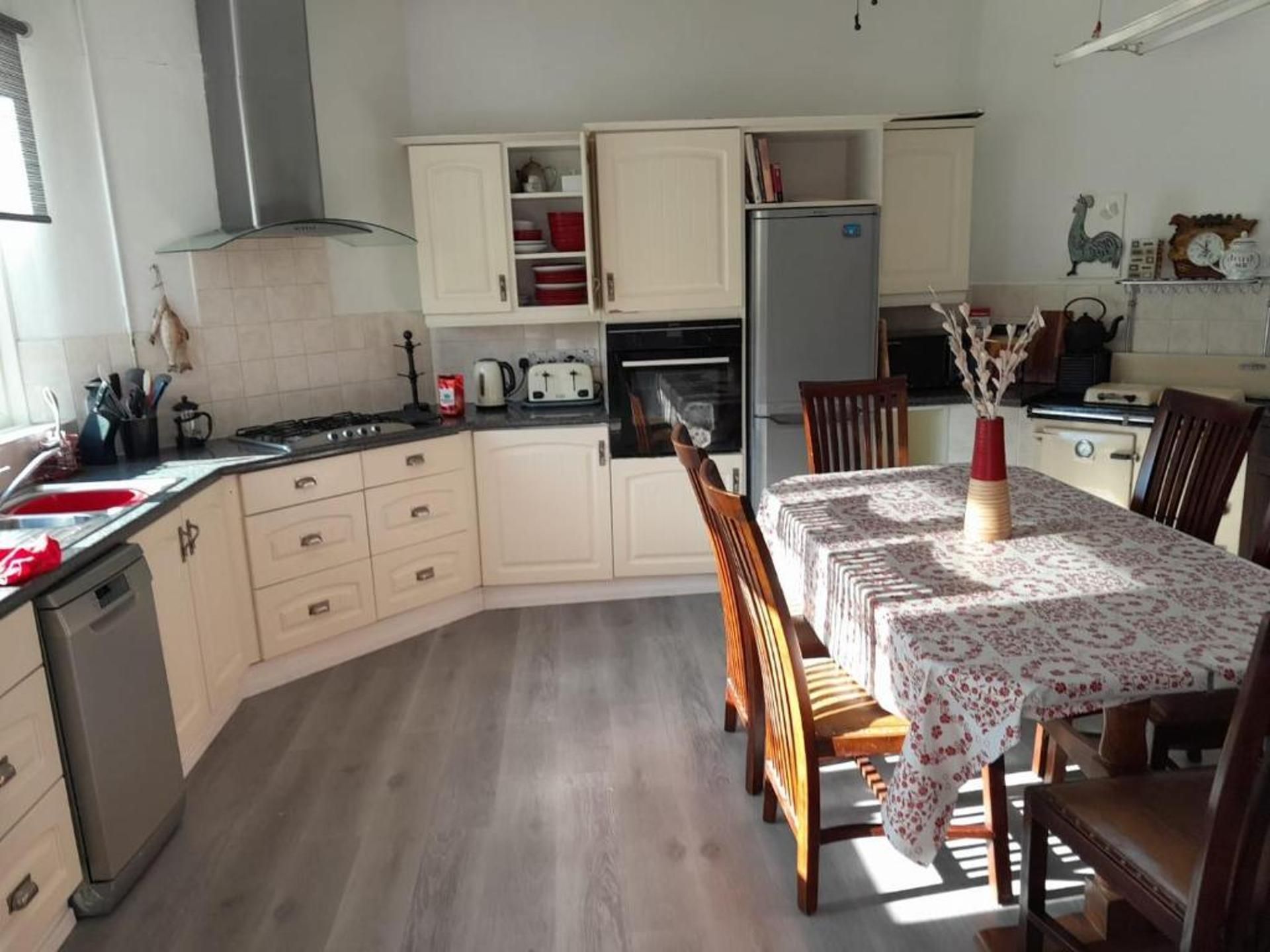 A kitchen with a dining table, chairs, and a refrigerator.