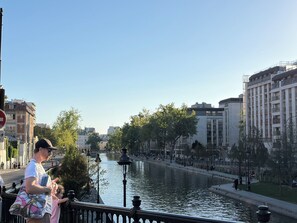 Un río con un puente, edificios y una pasarela para peatones.
