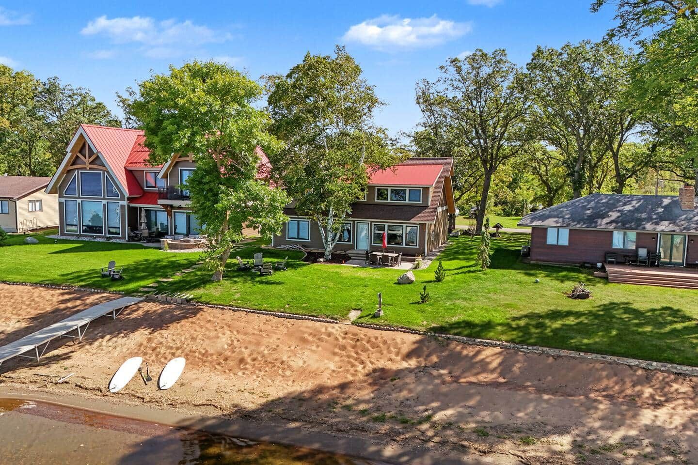 A residential area with multiple houses, a well-maintained lawn, and a dirt path.