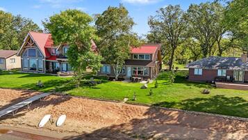 A residential area with multiple houses, a well-maintained lawn, and a dirt path.