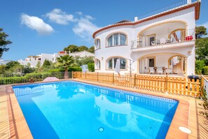 A two-story house with a swimming pool, a balcony with outdoor furniture, and a view of the surrounding landscape. - Villa 'Vera' with sea view, Wi-Fi, heated pool and air conditioning (Balcó al Mar)