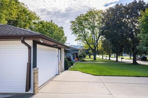 A residential property with a garage, a driveway, and a well-maintained lawn. - Walking distance to Lambeau Field- Dog Friendly! (Green Bay)