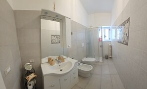 A modern bathroom with a sink, mirror, toilet, bidet, and shower. - La Dimora Di Mari—10 minutes from Sassi—easy parking—Wi-Fi (Matera)