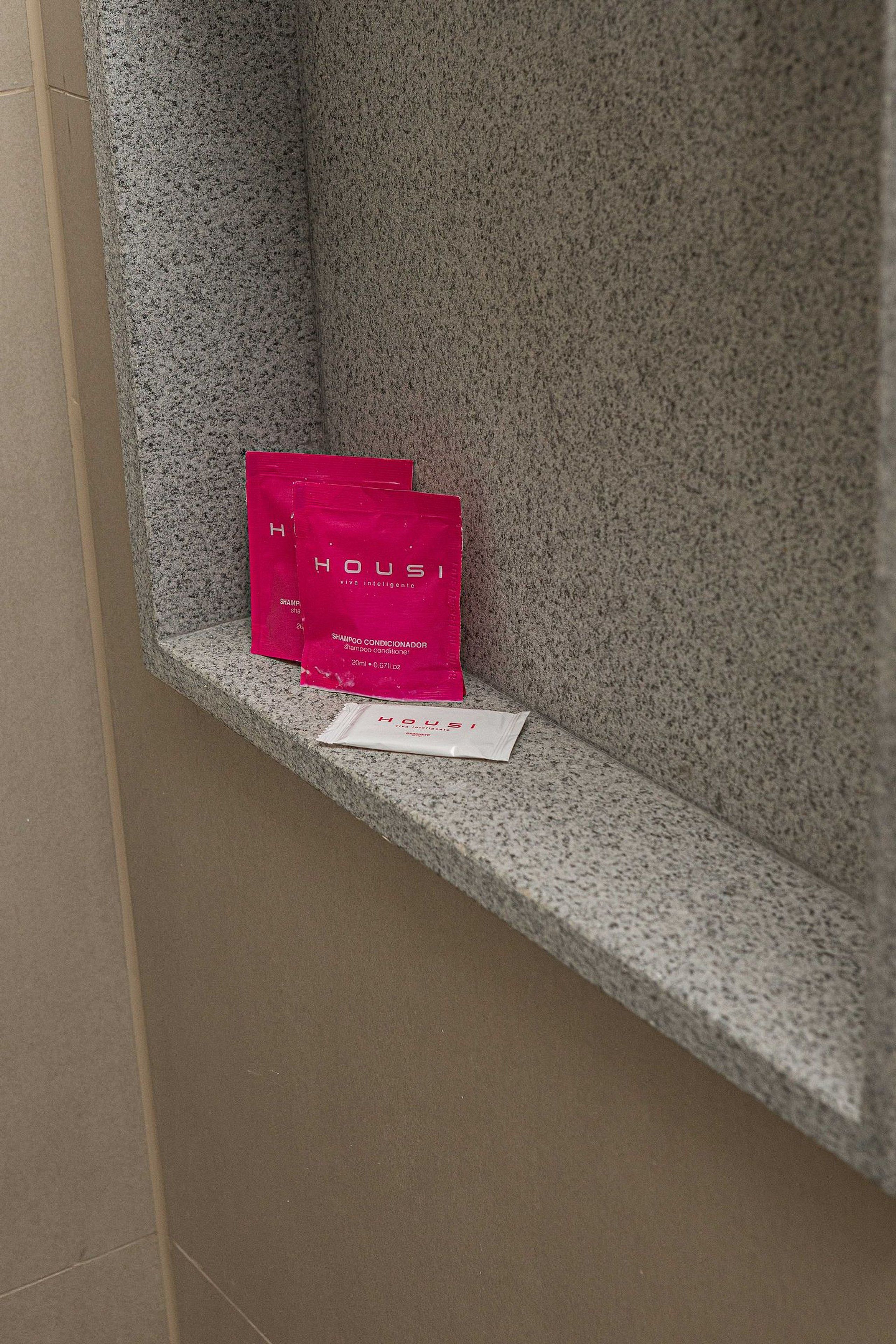 A granite bench with two pink bags and a white tag on it.