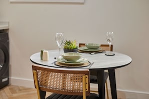 A round dining table with a white tablecloth, two chairs, and a small potted plant. - Host & Stay - The Signature Suite (Middlesbrough)