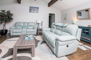 Ein Wohnzimmer mit Ecksofa, Couchtisch und einer Topfpflanze.