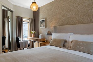 A hotel room with a large bed, a desk, a chair, and a window with curtains. - Lochburn House | Garden, Parking & Stylish 3BR (Glasgow)