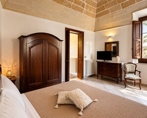 A bedroom with a bed, a wardrobe, a television on a dresser, a chair, and a window with a view. - LIVING IN Ástricu (Lecce)