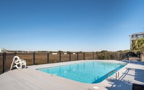 A swimming pool with a metal ladder, surrounded by a fence, and a clear sky above. - The Breakers Paradise - New Listing (Carolina Beach)