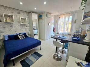 A compact room with a bed, a small kitchenette, and a dining area. - La Vela Recanati-studio con Accesso Alla Spiaggia (Giardini Naxos)