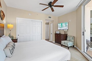 A hotel room with a large bed, a ceiling fan, a television, a dresser, and a chair. - ⛱️Palms 2203 - Beach Nearby + Lagoon Pool + Free Seasonal Shuttle⛱️ (Destin)