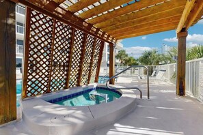 A covered outdoor swimming pool with a wooden pergola and a metal ladder. - 🌅Walk to Beach | Gulf & Lake Views | Pelican Terrace 905🌴 (Destin)