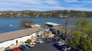 A waterfront property with a parking lot, a dock, and a view of the lake. - Lake Life Starts Here! Free Boat Slip & Epic Views (Osage Beach)