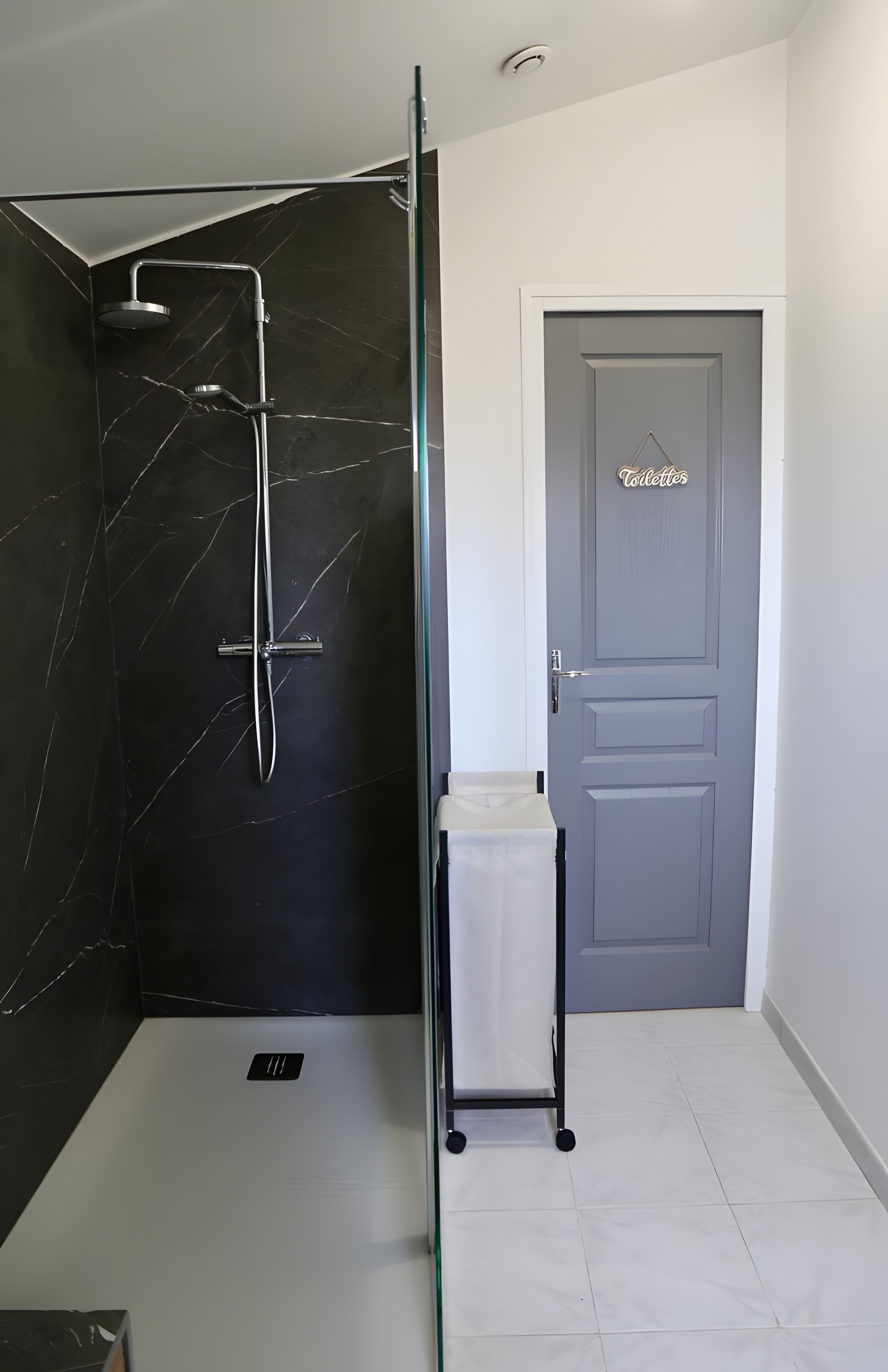 Un baño moderno con ducha envuelta en vidrio, inodoro y lavamanos.