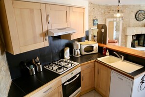 A compact kitchen with a gas stove, microwave, and a dishwasher.